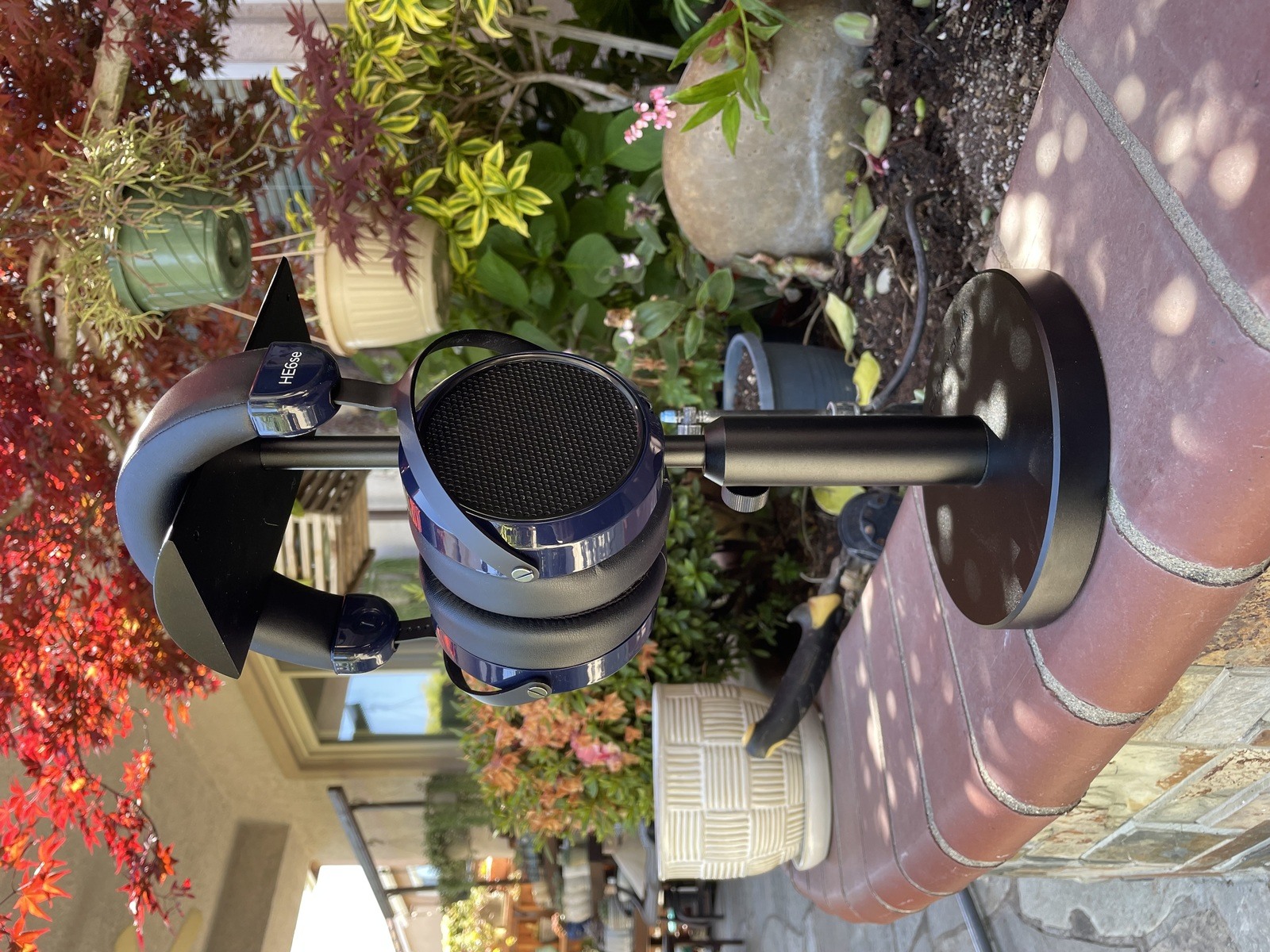 HIFIMAN HE6se V2 on Woo Audio HPS-T headphone stand next to garden